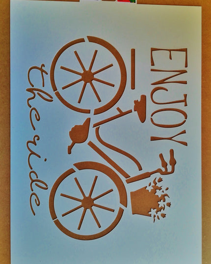 A bicycle-shaped stencil with the phrase 'Enjoy the ride' written vertically alongside the image.